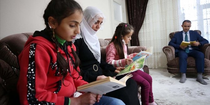 Gönüllü öğretmenler evleri ziyaret edip öğrenci ve velilerle kitap okuyor